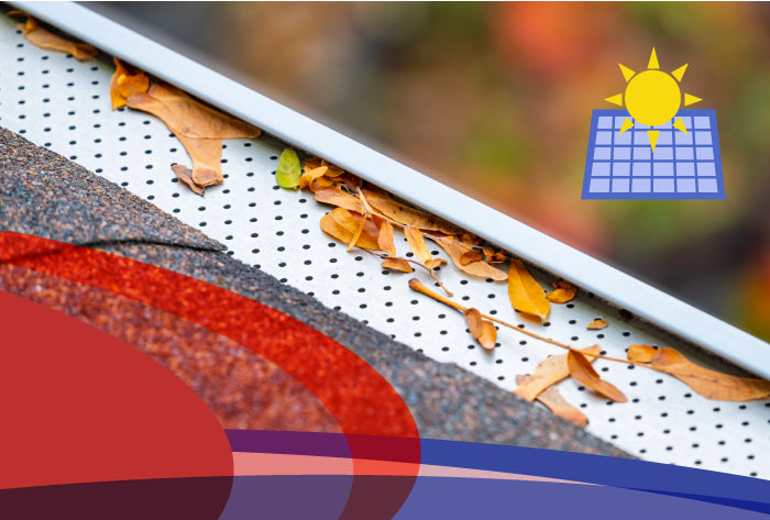 Micro-mesh style gutter guard with dry autumn leaves lying on top of the screen, successfully preventing debris from clogging the gutter trough